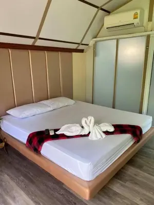 a bed with white sheets and a blanket on it at Kurina Hotel in Bangkok