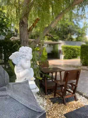 a white angel statue sitting on a table in a garden at Kurina Hotel in Bangkok