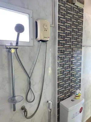 a shower in a bathroom with a toilet and a window at Kurina Hotel in Bangkok