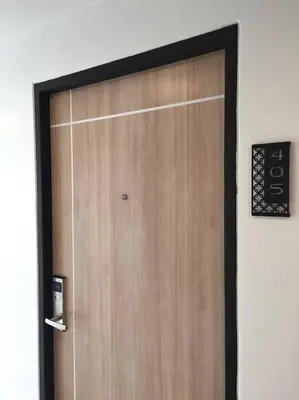 a wooden door with a sign on a wall at Live at Home Sukhumvit 105 in Bangkok