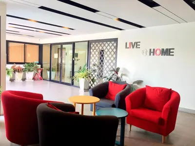 a lobby with red chairs and a living room at Live at Home Sukhumvit 105 in Bangkok