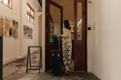 a woman in a dress standing at a door at Hostel Urby in Bangkok