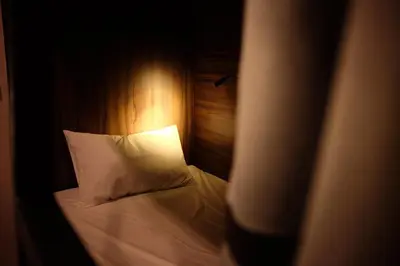 a bedroom with a bed with white pillows at Hostel Urby in Bangkok