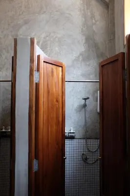 a bathroom with two wooden doors and a shower at Hostel Urby in Bangkok
