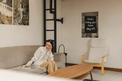 a woman sitting on a couch in a living room at Hostel Urby in Bangkok