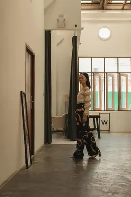 a woman walking down a hallway in a room at Hostel Urby in Bangkok