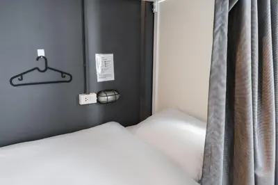 a bedroom with two beds and a hanger at The Cocoon Hostel in Bangkok