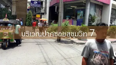 a man standing on a street in a city at Dazzle Residence in Bangkok
