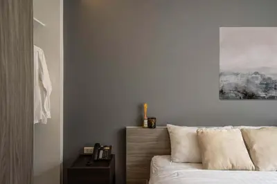a bedroom with a bed and a picture on the wall at Dazzle Residence in Bangkok