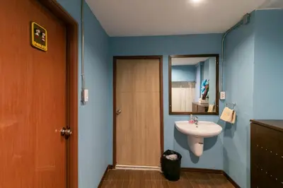 a bathroom with a sink and a mirror at Phobphan Hostel in Bangkok
