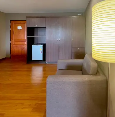 a living room with a couch and a kitchen at BU Place Hotel in Bangkok