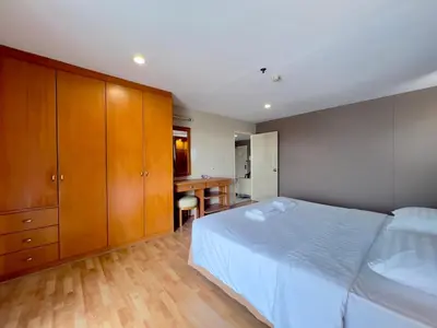 a bedroom with a white bed and wooden cabinets at BU Place Hotel in Bangkok