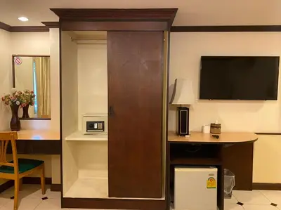 a hotel room with a door with a desk and a television at Honey House 2 in Bangkok