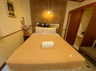 a bedroom with a large bed with a towel on it at Honey House 2 in Bangkok