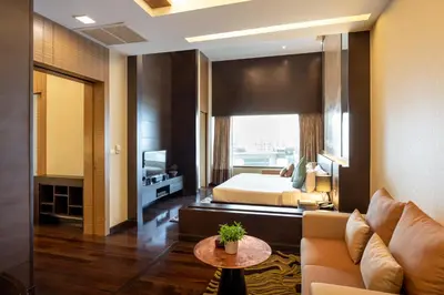 a hotel room with a bed and a couch at Jasmine Resort Bangkok in Bangkok