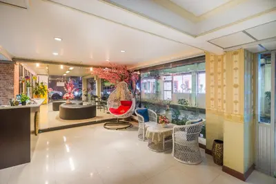 a lobby with chairs and tables in a building at The Corner Ratchada in Bangkok