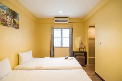 a hotel room with two beds and a window at The Corner Ratchada in Bangkok