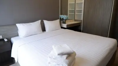 a bedroom with a white bed with towels on it at 18 Residence in Bangkok