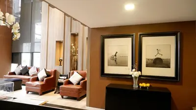 a living room with two chairs and a lobby at 18 Residence in Bangkok