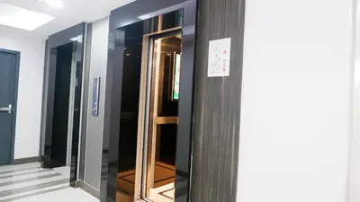 a row of glass elevators in a hallway at 18 Residence in Bangkok