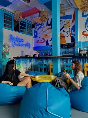 two people sitting on blue couches in a bar at Bodega Bangkok Soi 23 in Bangkok