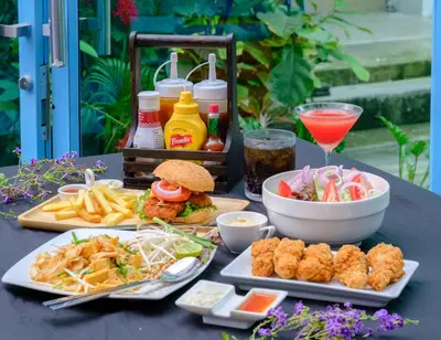 a table with plates of food and a drink at Bodega Bangkok Soi 23 in Bangkok