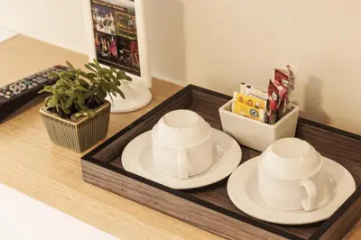 a tray with two cups and plates on a counter at Samran Place Hotel in Bangkok