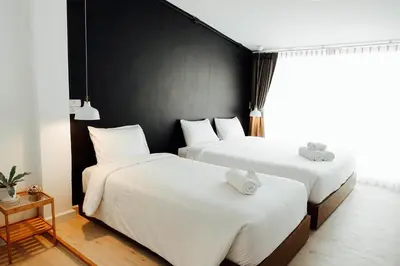 two beds in a room with black walls at Varmtel in Bangkok