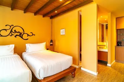 a bedroom with two beds and a yellow wall at Amber Boutique Silom in Bangkok