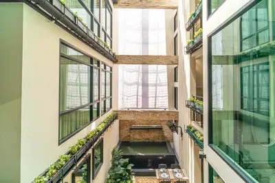 a hallway in a building with windows and plants at Amber Boutique Silom in Bangkok