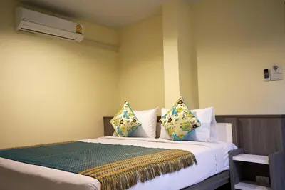 a bedroom with a bed with pillows and a heater at Samsen Sam Place in Bangkok