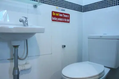 a bathroom with a white toilet and a sink at Samsen Sam Place in Bangkok