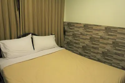 a bed with two pillows on it in a room at Samsen Sam Place in Bangkok