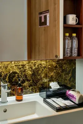 a bathroom counter with a sink and a mirror at VELA be Bangkok Ratchathewi in Bangkok