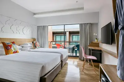 a hotel room with two beds and a television at VELA be Bangkok Ratchathewi in Bangkok