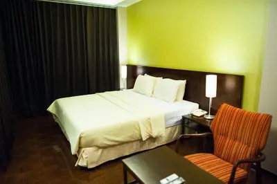 a hotel room with a bed and a table and a chair at Baansilom Soi 3 in Bangkok