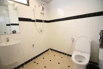a bathroom with a toilet and a sink at Kaya Place in Bangkok