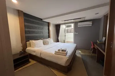 a bedroom with a bed with two towels on it at Eurna Resort Hotel in Bangkok