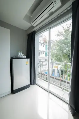 a room with a large window and a refrigerator at S44ROOM in Bangkok