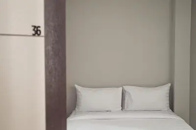 a bed with white pillows in a room at S44ROOM in Bangkok