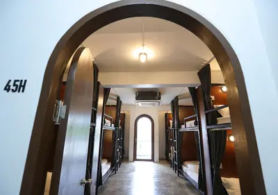 an archway leading into a room with bunk beds at Apartment45 Hostel in Bangkok