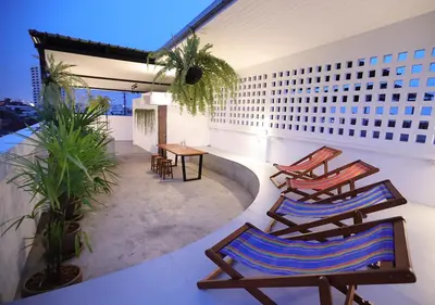 a balcony with chairs and a table on a building at Apartment45 Hostel in Bangkok