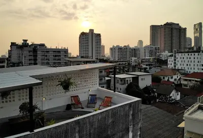 two chairs on the roof of a building in a city at Apartment45 Hostel in Bangkok