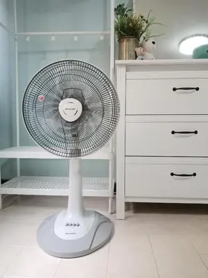 a white fan in a room next to a dresser at Nesto Condo at Muangthong in Pak Kret