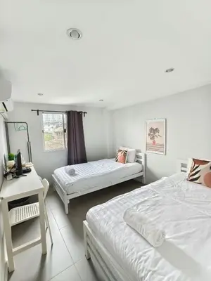 a bedroom with two beds and a desk and a mirror at 101 SEOUL HOSTEL (101 โซล โฮสเทล) in Bangkok