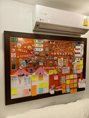 a bulletin board on a wall in a room at 101 SEOUL HOSTEL (101 โซล โฮสเทล) in Bangkok