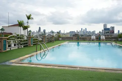a large swimming pool on the roof of a building at Royal Suite Hotel Bangkok in Bangkok
