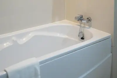 a bathroom with a sink with a faucet at Royal Suite Hotel Bangkok in Bangkok