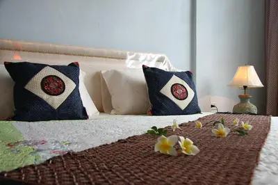a bed with two pillows and flowers on it at PR Place Hotel in Bangkok