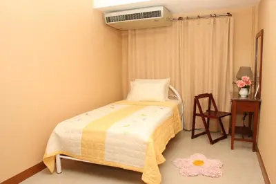 a bedroom with a bed and a air conditioner at PR Place Hotel in Bangkok